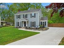 Charming two-story home with a well-manicured lawn, grey siding, black shutters and a welcoming front entrance at 11700 Fernhurst Ln, Charlotte, NC 28277