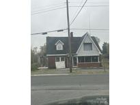 Exterior of building showing brick and paneled siding with a dark roof and several windows and a partial view of a street at 1214 Pee Dee Ave, Albemarle, NC 28001