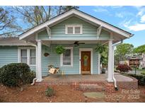 Charming covered front porch with swing, hanging plants, and traditional architectural details at 1801 Wilmore Dr, Charlotte, NC 28203