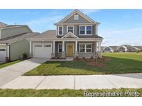 Charming two-story home with gray siding, stone accents, well-manicured lawn, and a welcoming yellow front door at 218 Lacewing Dr # 41, Charlotte, NC 28214
