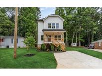 Charming new construction home with a covered front porch and lush green lawn at 2512 Remington St, Charlotte, NC 28216