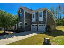 Beautiful two-story home featuring a two-car garage and manicured front lawn on a sunny day at 2716 Red Maple Ln # 122, Harrisburg, NC 28075