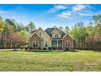 Charming home with stone accents, a covered porch, and a lush front yard at 3207 Oak Ridge Cir, Lincolnton, NC 28092