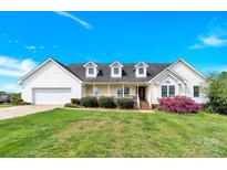 Charming two-story home with a well-manicured lawn, inviting front porch, and attached two-car garage at 365 Kinder Rd, Harmony, NC 28634