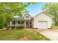 Charming home featuring a welcoming front porch, one car garage, and a well-maintained lawn with mature landscaping at 3790 Lynnview Ct, Maiden, NC 28650