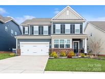 Charming two-story home with a well-maintained lawn, a two car garage and beautiful landscaping at 4024 Whipcord Dr, Waxhaw, NC 28173