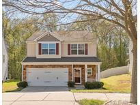 Charming two-story home with stone accents, a two-car garage, manicured lawn, and inviting curb appeal at 428 Winecoff Woods Nw Dr, Concord, NC 28027