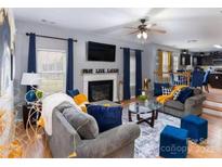 Inviting living room featuring hardwood floors, cozy fireplace, and an abundance of natural light at 5025 Wicklow Dr, Gastonia, NC 28054