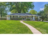 Charming single-story home boasts a lush green lawn and inviting walkway at 700 Cooper Dr, Charlotte, NC 28210