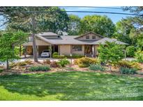 Charming home featuring lush landscaping and a convenient carport for easy parking at 10315 Washam Potts Rd, Cornelius, NC 28031