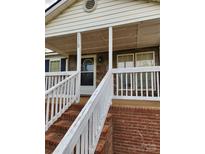 Charming front porch with stone accents, white railings, and brick stairs leading to a cozy entrance at 1110 Hollyberry Ln, Salisbury, NC 28147