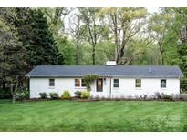 Charming single-story white home featuring a well-manicured lawn and inviting curb appeal at 1201 Robinhood Cir, Charlotte, NC 28227