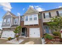 Charming townhome featuring brick facade, white garage door, and a well-manicured front yard at 1245 Pebble Grove Dr, Clover, SC 29710