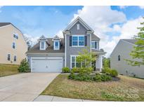 Charming two-story home featuring a manicured lawn, a two-car garage, and appealing architectural details at 16803 Cozy Cove Rd, Charlotte, NC 28278