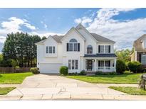 Inviting two-story home with a manicured lawn, attached garage, and a charming front porch at 17309 Knoxwood Dr, Huntersville, NC 28078