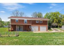 Two-story brick home featuring an attached two-car garage and a large front yard with lush green grass at 175 Neita Dr, Salisbury, NC 28147