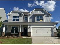 Charming two-story home features a two-car garage and a beautifully landscaped front yard on a sunny day at 2017 Embassy Ct # 51, Charlotte, NC 28213