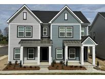 Charming townhome featuring stylish two-tone exterior, modern windows, and inviting covered entry at 4004 Crooked Spruce Ct, Matthews, NC 28105