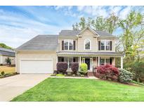 Charming two-story home with a welcoming front porch and well-manicured landscaping and an attached two-car garage at 4086 Buckingham Dr, Fort Mill, SC 29707
