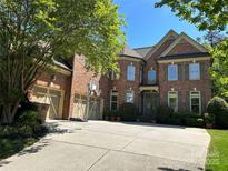 Stately brick home with a three-car garage, basketball hoop, and mature landscaping at 1024 Westbury Dr, Matthews, NC 28104