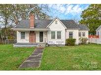 Charming single-story home with a brick chimney and a well-maintained front yard at 106 Courtland St, Chester, SC 29706