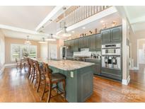 Open concept kitchen boasts granite counters, stainless appliances, and modern lighting at 1151 Trull Hinson Rd, Wingate, NC 28174