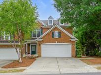 Charming two-story brick home with a two-car garage, manicured lawn, and colorful landscaping at 15643 Canmore St, Charlotte, NC 28277