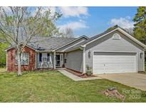 Charming single-Gathering home with brick and vinyl siding, a well-maintained lawn, and an attached two-car garage at 239 Bradford Glyn Dr, Mooresville, NC 28115