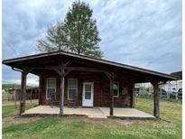 Cozy cabin with a covered porch and rocking chairs, nestled in a serene outdoor setting at 291 Love Valley Rd, Statesville, NC 28625