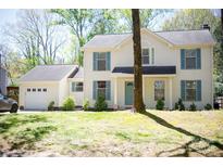 Charming two-story home featuring blue shutters, a front yard, and an attached garage at 6718 Rollingridge Dr, Charlotte, NC 28211