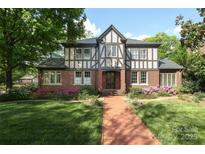 Charming Tudor-style home with brick facade, lush landscaping, and a welcoming brick walkway at 801 Berkeley Ave, Charlotte, NC 28203
