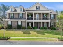 Stunning two-story brick home featuring a charming double porch and well-manicured lawn at 8618 Whitehawk Hill Rd, Waxhaw, NC 28173
