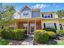 Charming townhome with a brick facade, lush landscaping, and inviting front porch at 9036 Four Mile Creek Rd, Charlotte, NC 28277
