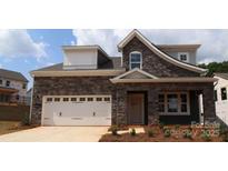 Charming two-story home with a stone facade, a two-car garage, and a well-manicured lawn at 1235 Yellow Springs Dr, Huntersville, NC 28078