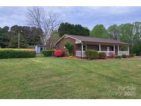 Charming brick home featuring a lush lawn, tidy landscaping, and a welcoming front porch at 1663 Smyre Farm Rd # 5, Newton, NC 28658