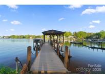 Picturesque lake view from a private covered dock with boat lift ready for summer fun at 20428 Island Forest Dr, Cornelius, NC 28031