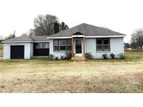 Charming single-story brick home with a black garage door and a welcoming front entrance at 2404 Old Camden Hwy, Lancaster, SC 29720