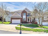 Inviting two-story home featuring a brick facade, manicured lawn, and a two-car garage at 2425 Orofino Ct, Charlotte, NC 28269