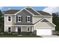 Charming two-story home featuring a mix of siding and stone accents, an attached two-car garage, and manicured landscaping at 274 Winford Rd, Troutman, NC 28116