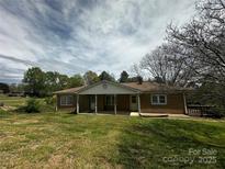 A charming single-story home featuring a brick facade, covered porch, and spacious front yard at 3253 Centergrove Rd, Kannapolis, NC 28083