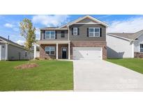 Charming two-story home with a brick and gray siding, a well-manicured lawn, and an attached two-car garage at 4610 Harris Elliot Rd, Lincolnton, NC 28092