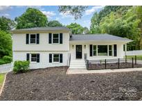 Traditional two-story home with black shutters, freshly painted and landscaping in front yard at 8025 Cliffside Dr, Charlotte, NC 28270