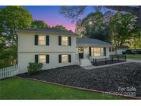 Charming two-story home featuring a well-manicured lawn and inviting front porch at 8025 Cliffside Dr, Charlotte, NC 28270