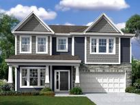 Two-story home with blue siding, stone accents, gabled roof, and an attached two-car garage at 8613 Bridgegate Dr, Huntersville, NC 28078