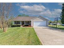 Charming single-story home featuring a well-manicured lawn, two-car garage, and a basketball hoop at 106 Zurich Ln, Statesville, NC 28625