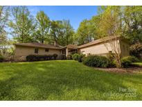 Expansive lawn and brick home exterior, accented by lush greenery, creating a serene outdoor space at 1676 Partridge Cir, Lancaster, SC 29720