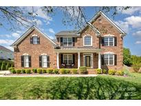 Charming brick home featuring a manicured lawn and beautiful, symmetrical landscaping at 2003 Ptarmigan Ct, Waxhaw, NC 28173