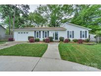 Charming one-story home with well-manicured lawn and walkway, black shutters, and attached garage at 22025 Torrence Chapel Rd, Cornelius, NC 28031
