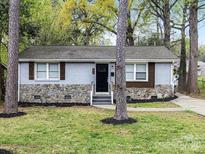 Charming single-story home featuring stone accents, grey siding, black door, and a well-maintained lawn at 2815 Grimes St, Charlotte, NC 28206