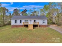 Charming single-story home featuring a freshly stained front porch and a well-maintained yard in a tranquil setting at 2895 Sweeping Pine Ln, Denver, NC 28037